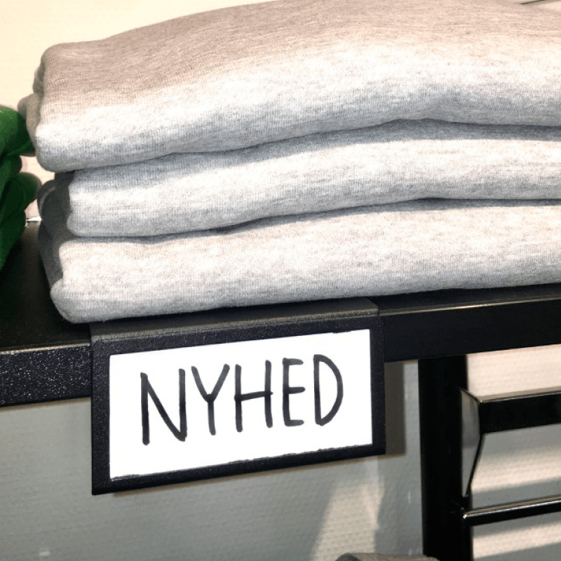 Sort metal indstiksplade til hyldeforkant